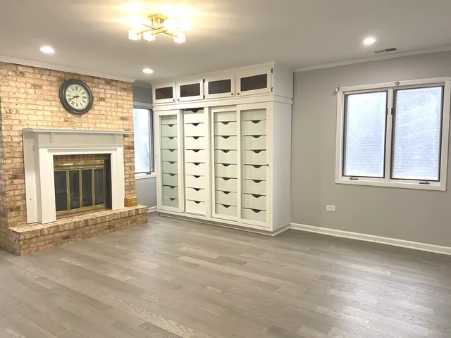 an empty room with windows and fireplace