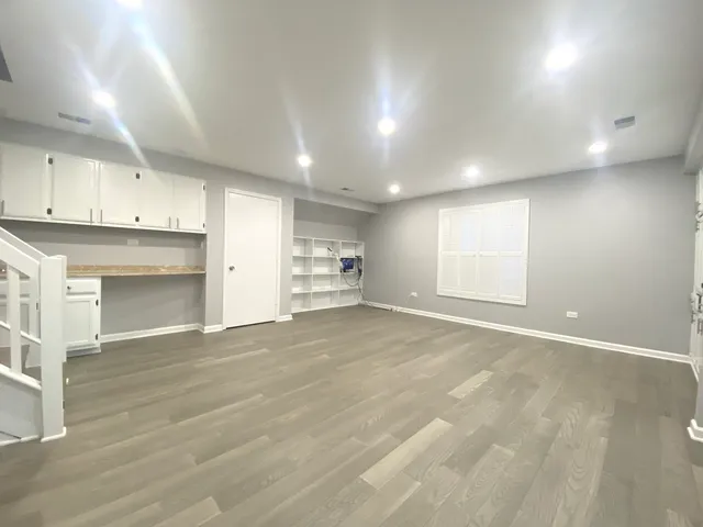 an empty room with cabinet and windows