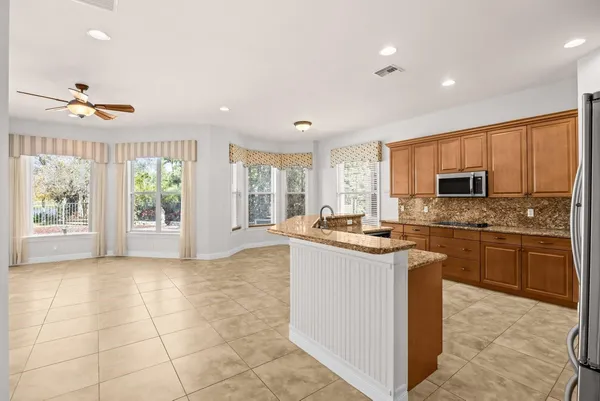 a kitchen with kitchen island granite countertop a stove sink and microwave
