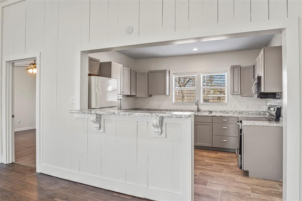 442 West McCart Street Krum, TX 76249 - Photo 11 of 40 a kitchen with stainless steel appliances granite countertop a sink and cabinets