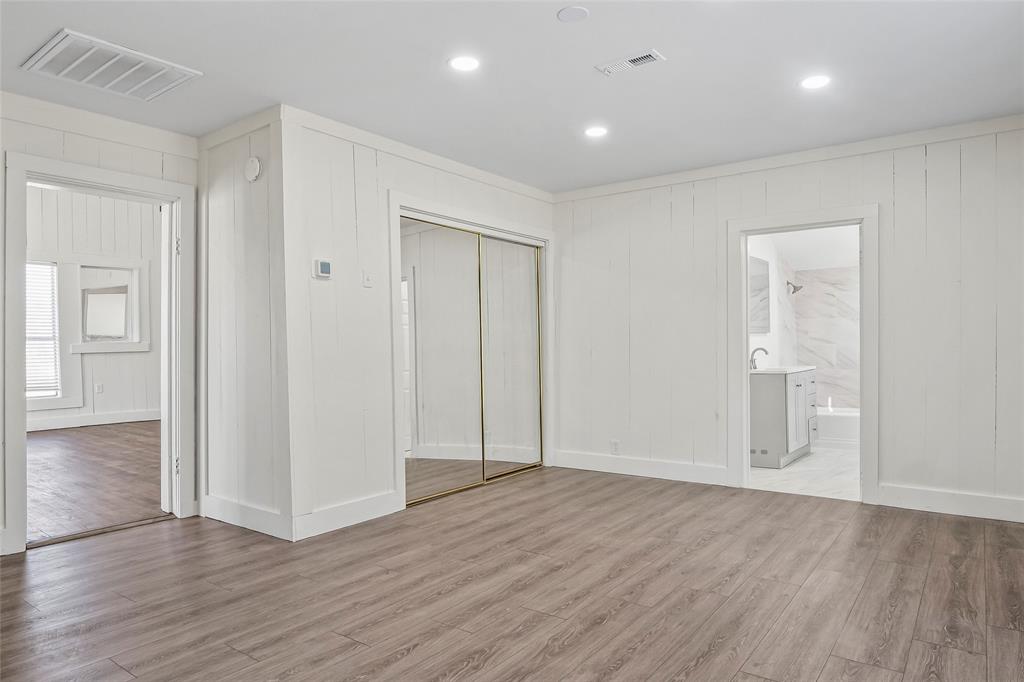 442 West McCart Street Krum, TX 76249 - Photo 22 of 40 an empty room with wooden floor & windows and bathroom