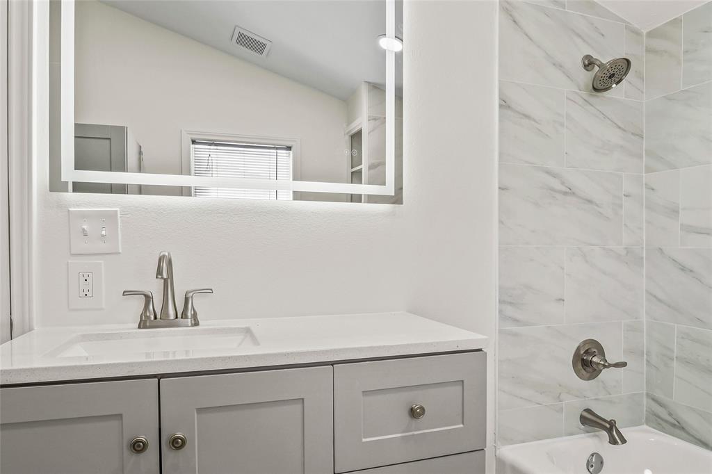 442 West McCart Street Krum, TX 76249 - Photo 24 of 40 a bathroom with a sink and a mirror