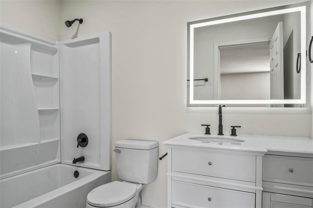 442 West McCart Street Krum, TX 76249 - Photo 35 of 40 a bathroom with a sink toilet a vanity and shower