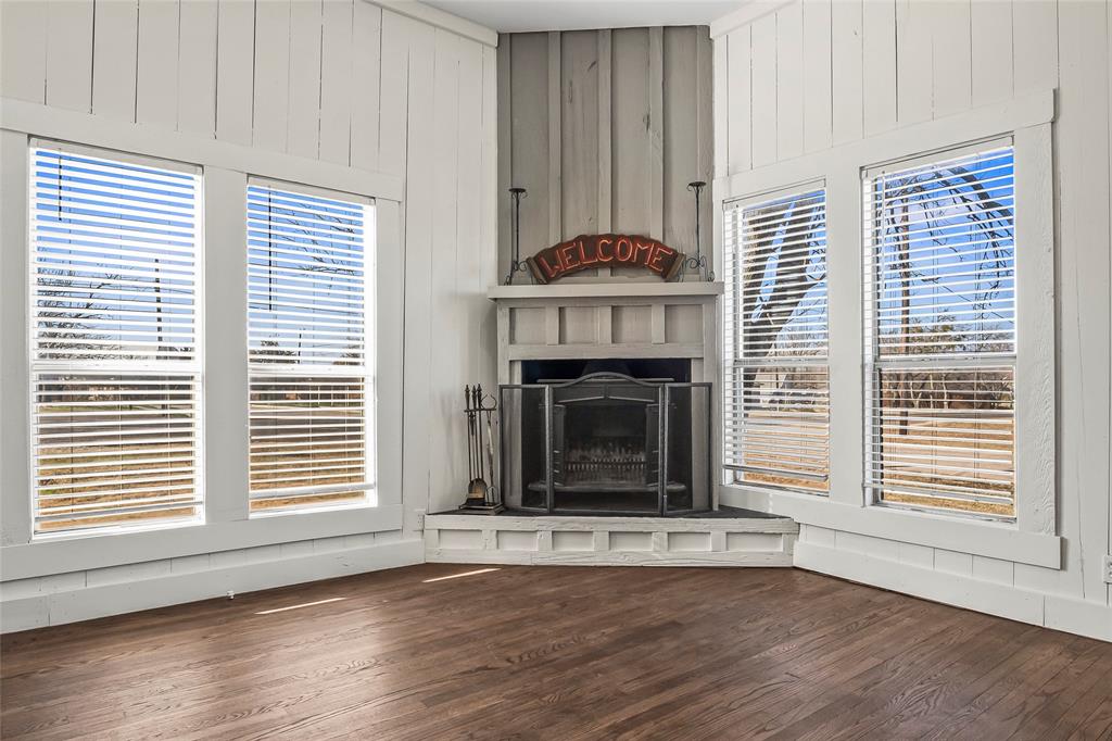 442 West McCart Street Krum, TX 76249 - Photo 6 of 40 a living room with fireplace and wooden floor