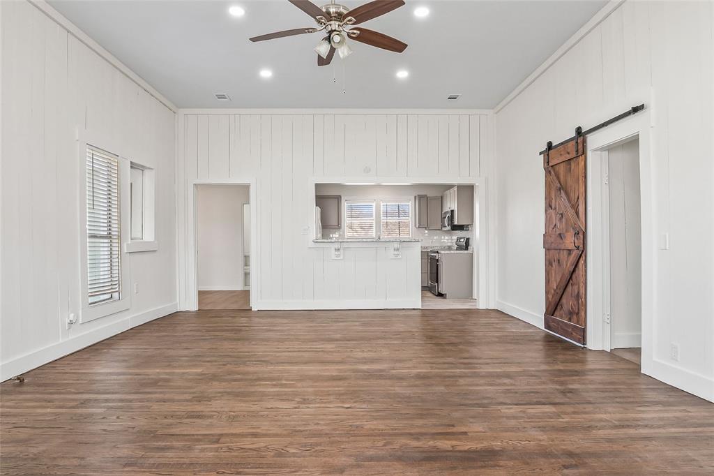 442 West McCart Street Krum, TX 76249 - Photo 7 of 40 a view of a kitchen with wooden floor and a ceiling fan