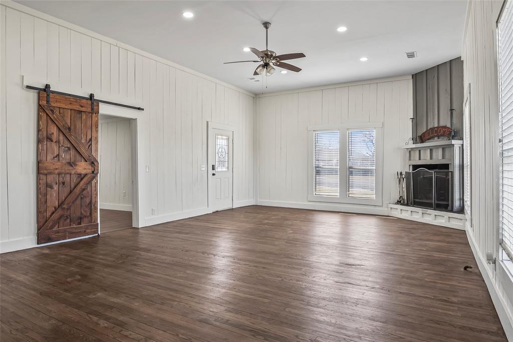 442 West McCart Street Krum, TX 76249 - Photo 9 of 40 a view of an empty room with a window and wooden floor