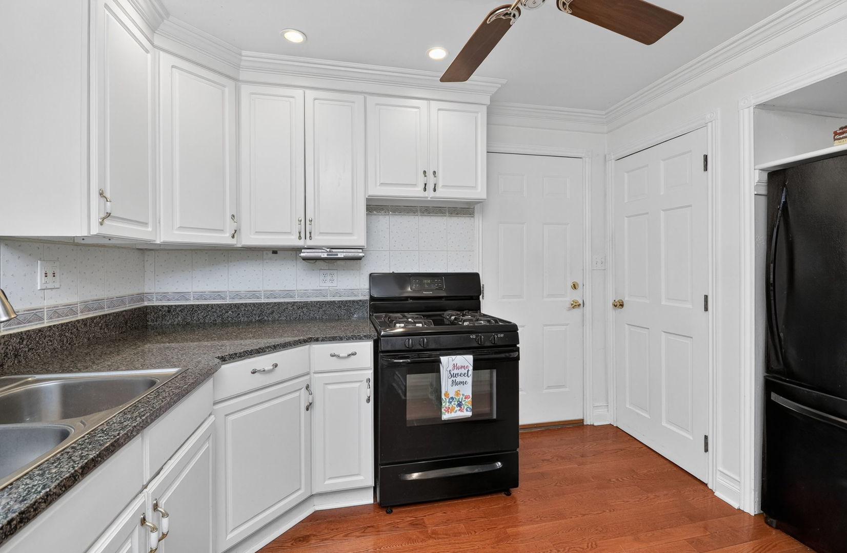 32W183 Glos Street Wayne, IL 60184 - Photo 8 of 30 a kitchen with a refrigerator stove and white cabinets