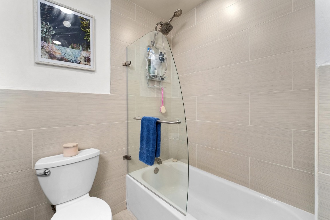 1210 Windsor Road, Unit 122 Austin, TX 78703 - Photo 22 of 24 Full bath featuring tub / shower combination and tile walls