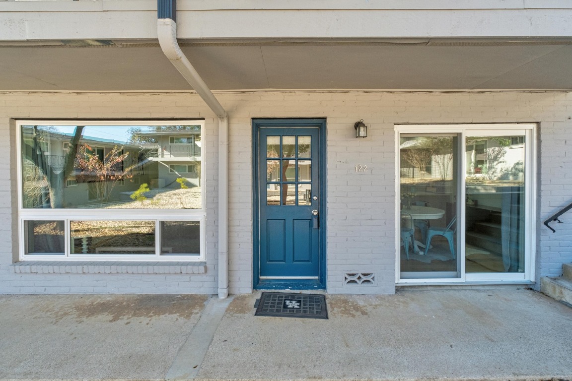 1210 Windsor Road, Unit 122 Austin, TX 78703 - Photo 3 of 24 Doorway to property featuring brick siding and covered porch