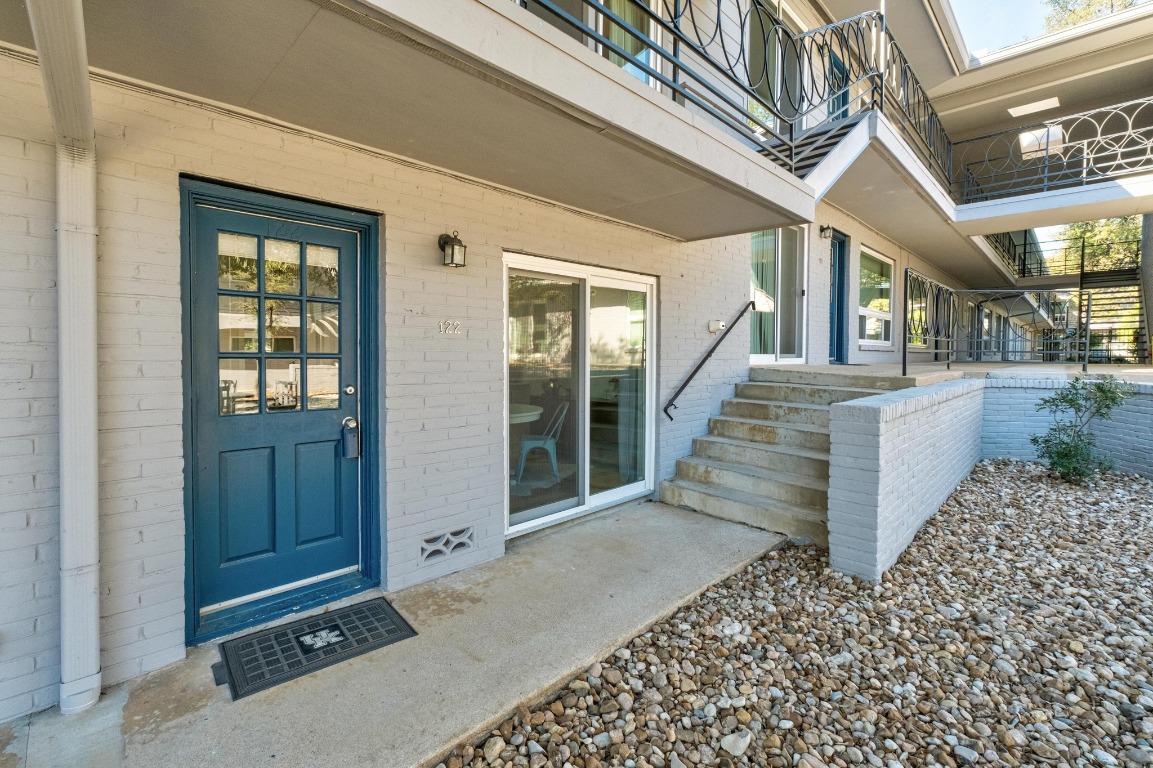 1210 Windsor Road, Unit 122 Austin, TX 78703 - Photo 4 of 24 Doorway to property with a patio and brick siding