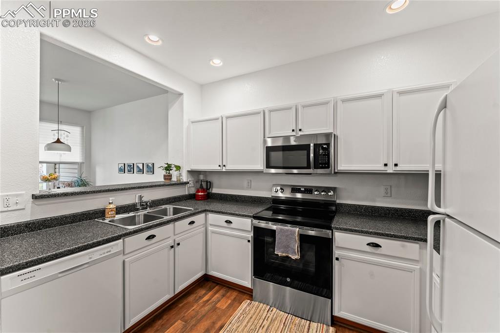 7362 Sandy Springs Point Fountain, CO 80817 - Photo 12 of 41 a kitchen with stainless steel appliances granite countertop a stove a sink and a microwave