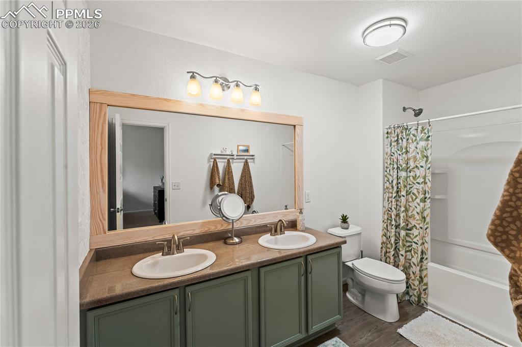 7362 Sandy Springs Point Fountain, CO 80817 - Photo 19 of 41 a bathroom with a granite countertop sink toilet a mirror and shower