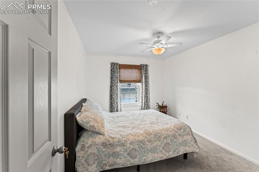 7362 Sandy Springs Point Fountain, CO 80817 - Photo 22 of 41 a bedroom with a bed and a chandelier