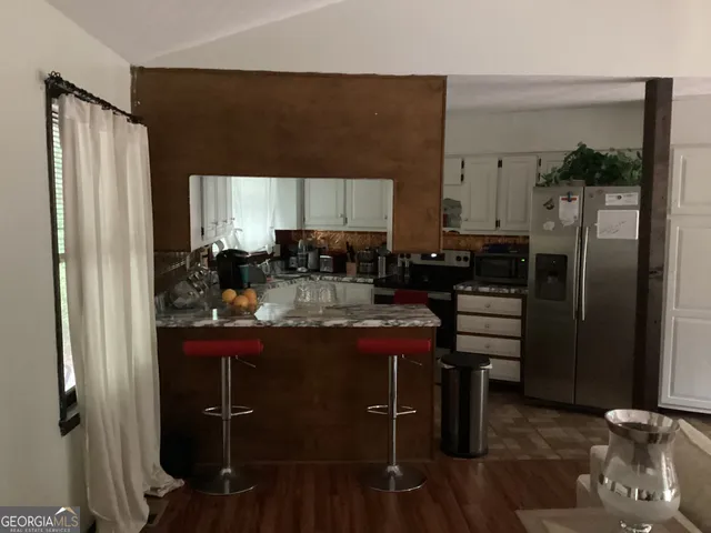 a kitchen with refrigerator and cabinets