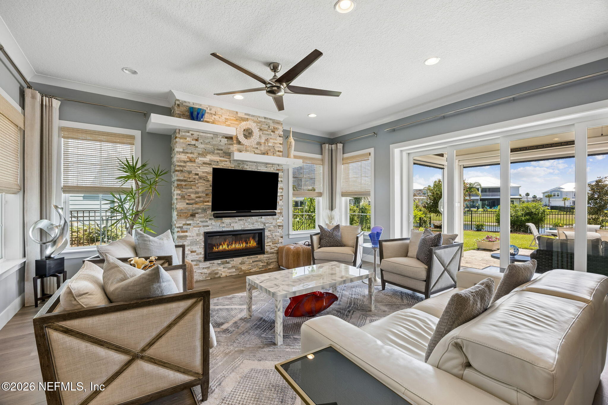 a living room with furniture a flat screen tv and a large window