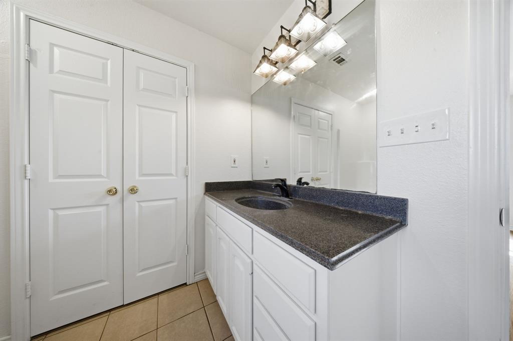697 County Road 166 Whitesboro, TX 76273 - Photo 13 of 32 a bathroom with a sink vanity and a mirror