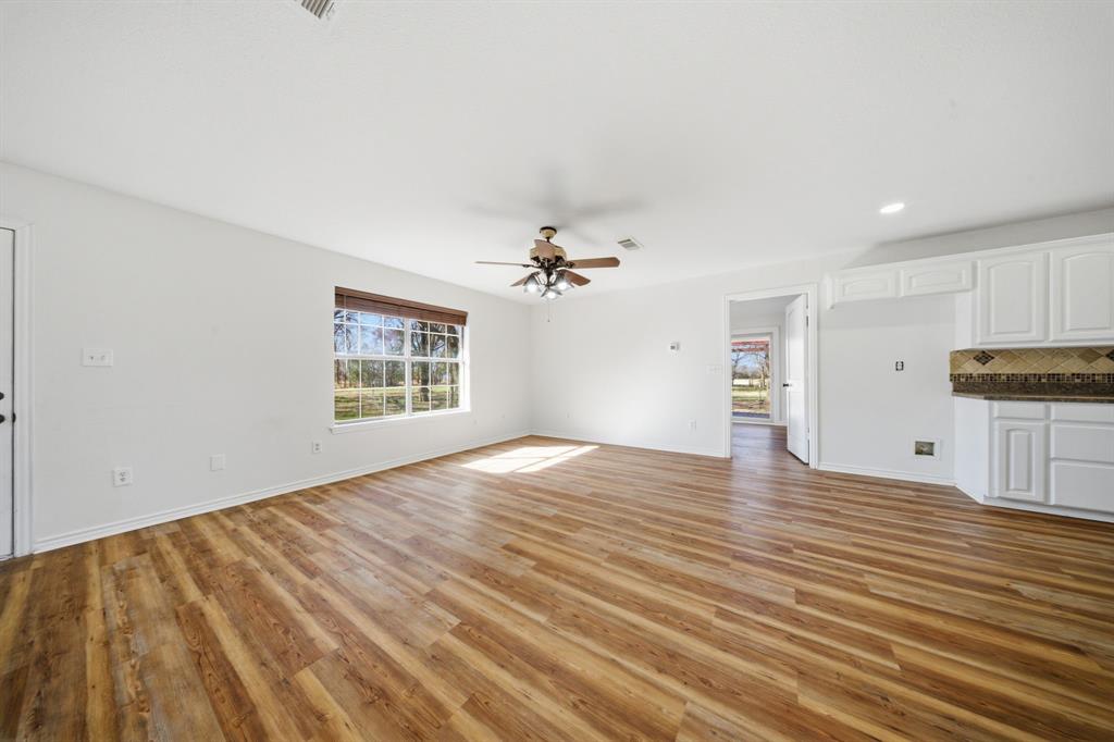 697 County Road 166 Whitesboro, TX 76273 - Photo 6 of 32 wooden floor in an empty room with a window