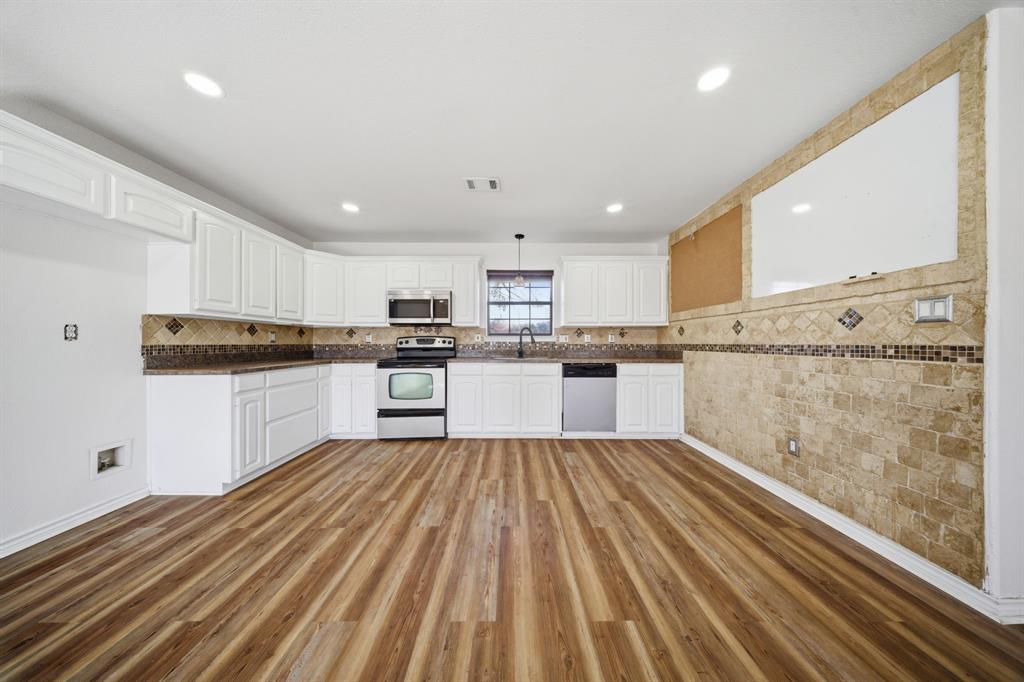 697 County Road 166 Whitesboro, TX 76273 - Photo 7 of 32 a kitchen with granite countertop stainless steel appliances and white cabinets