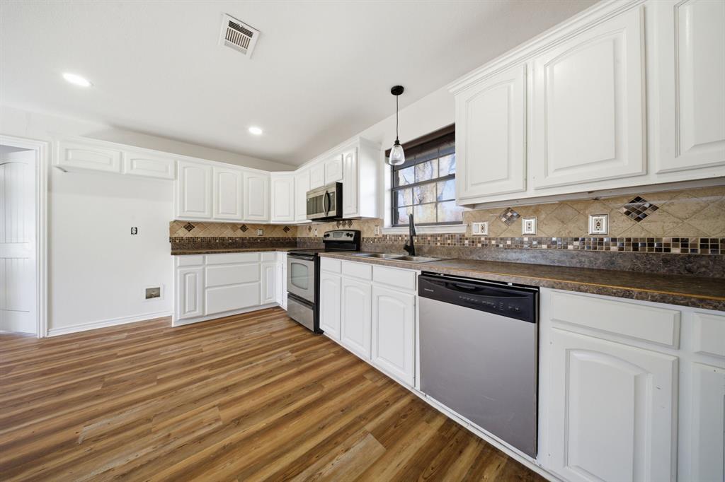 697 County Road 166 Whitesboro, TX 76273 - Photo 8 of 32 a kitchen with granite countertop white cabinets and white appliances