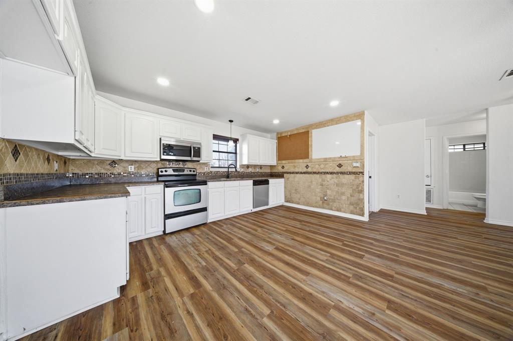 697 County Road 166 Whitesboro, TX 76273 - Photo 9 of 32 a kitchen with stainless steel appliances granite countertop a stove top oven a sink dishwasher and a refrigerator with wooden floor