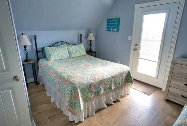 a bedroom with a bed and a flat tv screen on the dresser