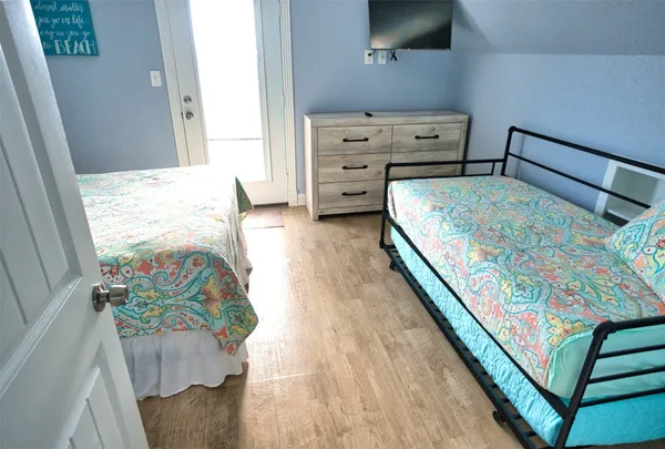 a bedroom with a bed a flat screen tv and a ceiling fan