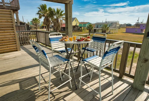 a view of a balcony with chairs and iron stairs