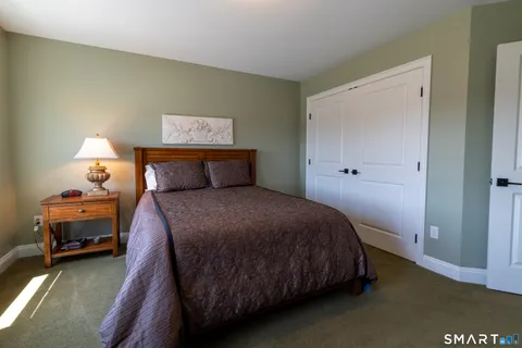 a bedroom with a bed and a lamp on the dresser