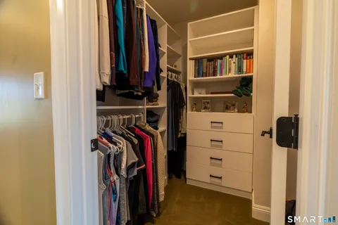 a view of walk in closet with clothes and shoes