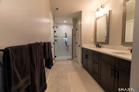 a bathroom with double vanity and mirrors