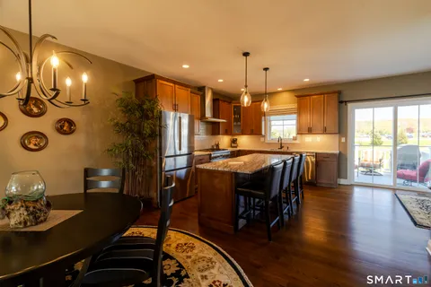 a kitchen with stainless steel appliances granite countertop a sink a stove and a refrigerator
