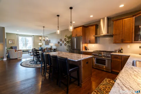 a kitchen with a table chairs stove and wooden floor