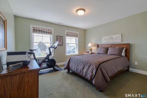 a bedroom with a bed and a dresser next to a window