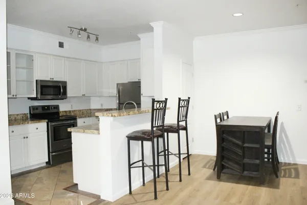 a kitchen with a table chairs microwave and refrigerator