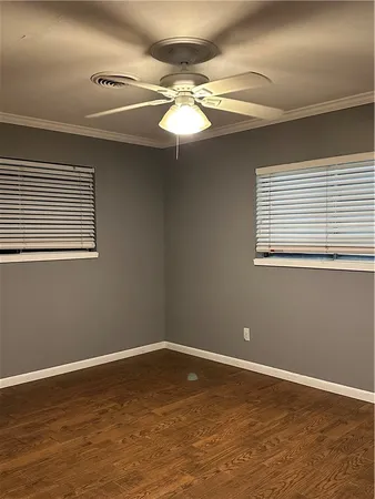 a view of a room with wooden floor and fan