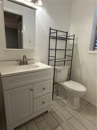 a bathroom with a granite countertop toilet sink and mirror