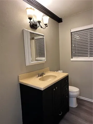 a bathroom with a granite countertop sink toilet a mirror and shower
