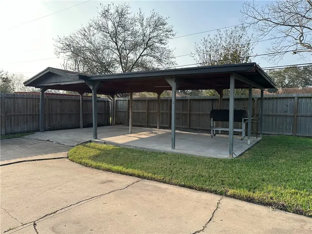 a view of a chair and table in backyard of the house