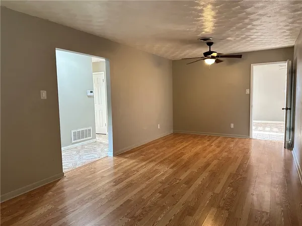 a view of empty room with wooden floor