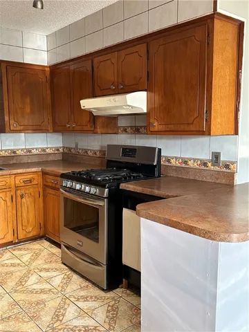 a kitchen with stainless steel appliances granite countertop a stove a sink and a microwave