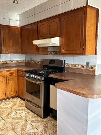 a kitchen with stainless steel appliances granite countertop a stove a sink and a microwave