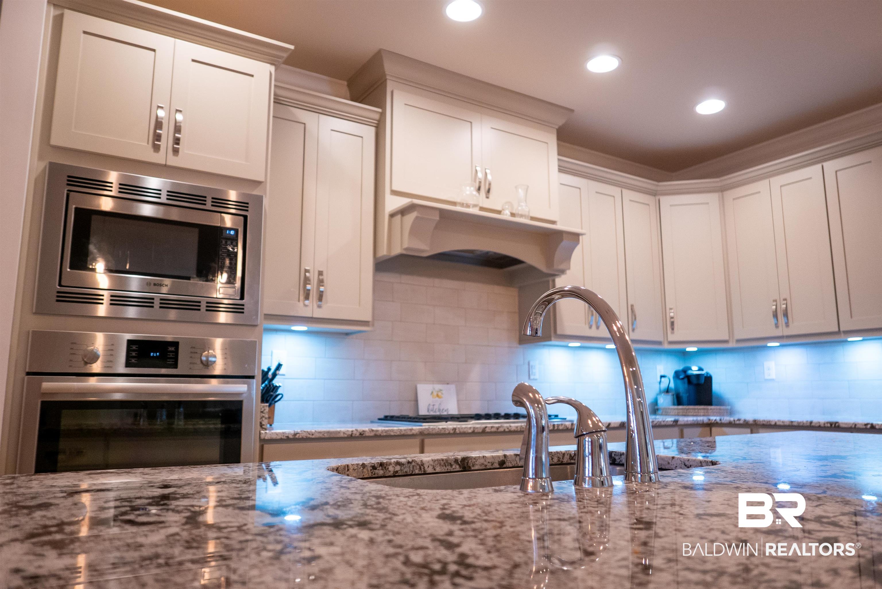 6684 Garrison Drive Daphne, AL 36527 - Photo 5 of 35 Kitchen featuring appliances with stainless steel finishes, white cabinets, and light stone counters