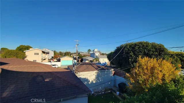 a view of a hallway with wooden floor and a kitchen