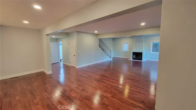 a large kitchen with stainless steel appliances kitchen island granite countertop a refrigerator a sink and wooden cabinets