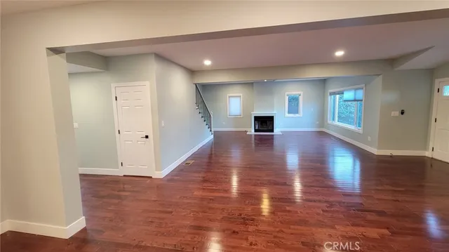 a large kitchen with stainless steel appliances a large counter top a stove and a wooden floors