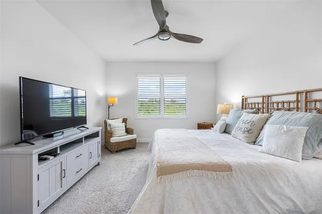 a spacious bedroom with a bed and a flat screen tv