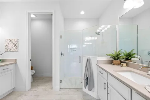 a bathroom with a sink a toilet and a large mirror