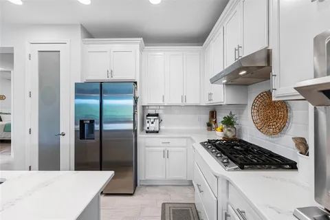 a kitchen with stainless steel appliances a stove a refrigerator and cabinets