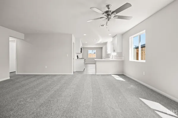a view of a livingroom with a ceiling fan a ceiling fan and a window