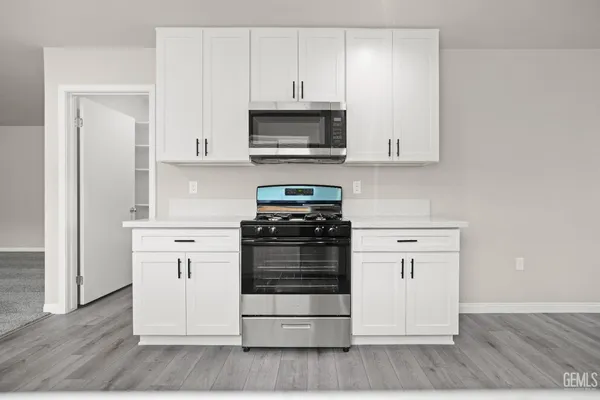 a kitchen with white cabinets and stainless steel appliances